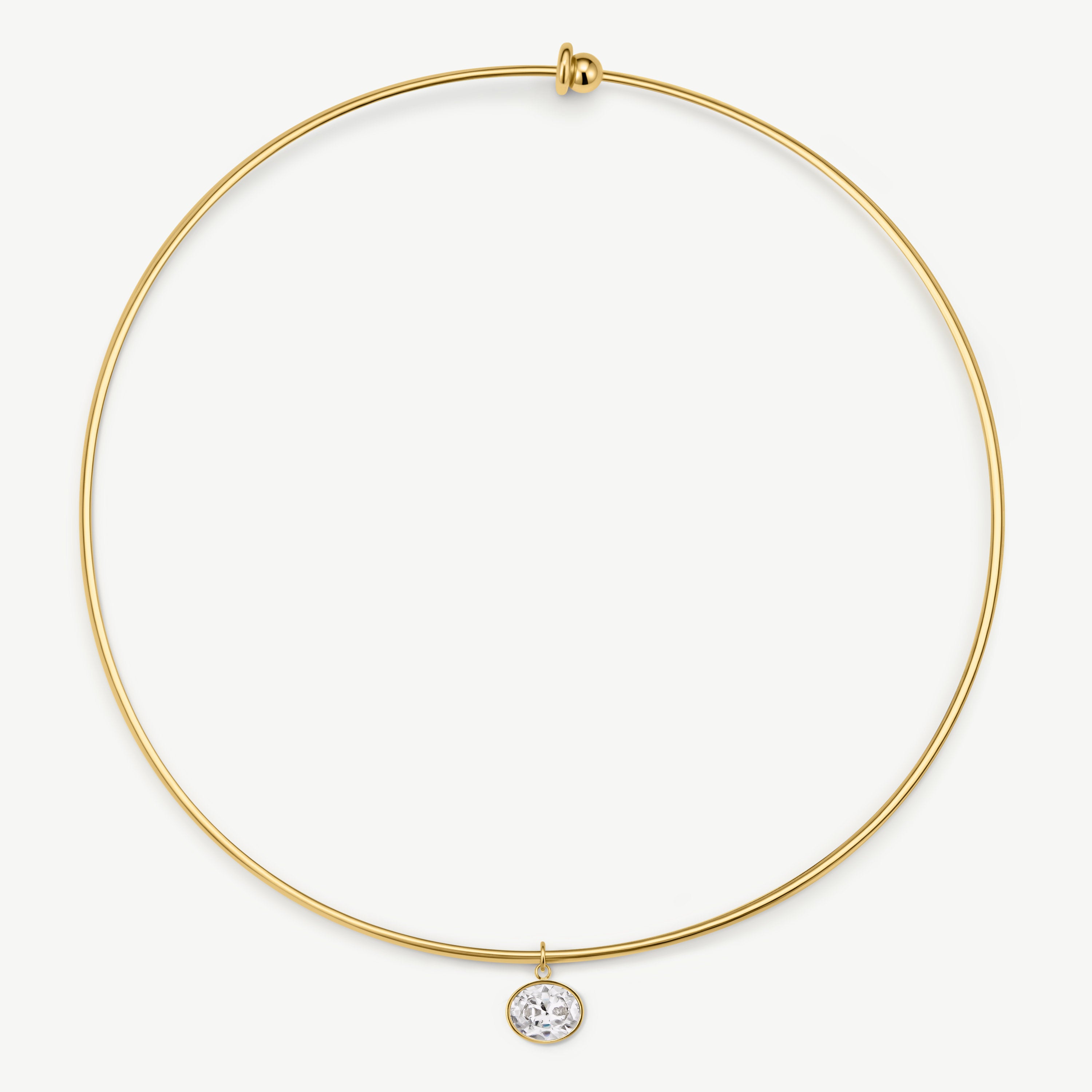 A delicate gold wire circle necklace with a small bezel-set clear gemstone pendant, shown on a clean off-white background.