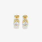 Gold earrings with clear gemstones on a white background
