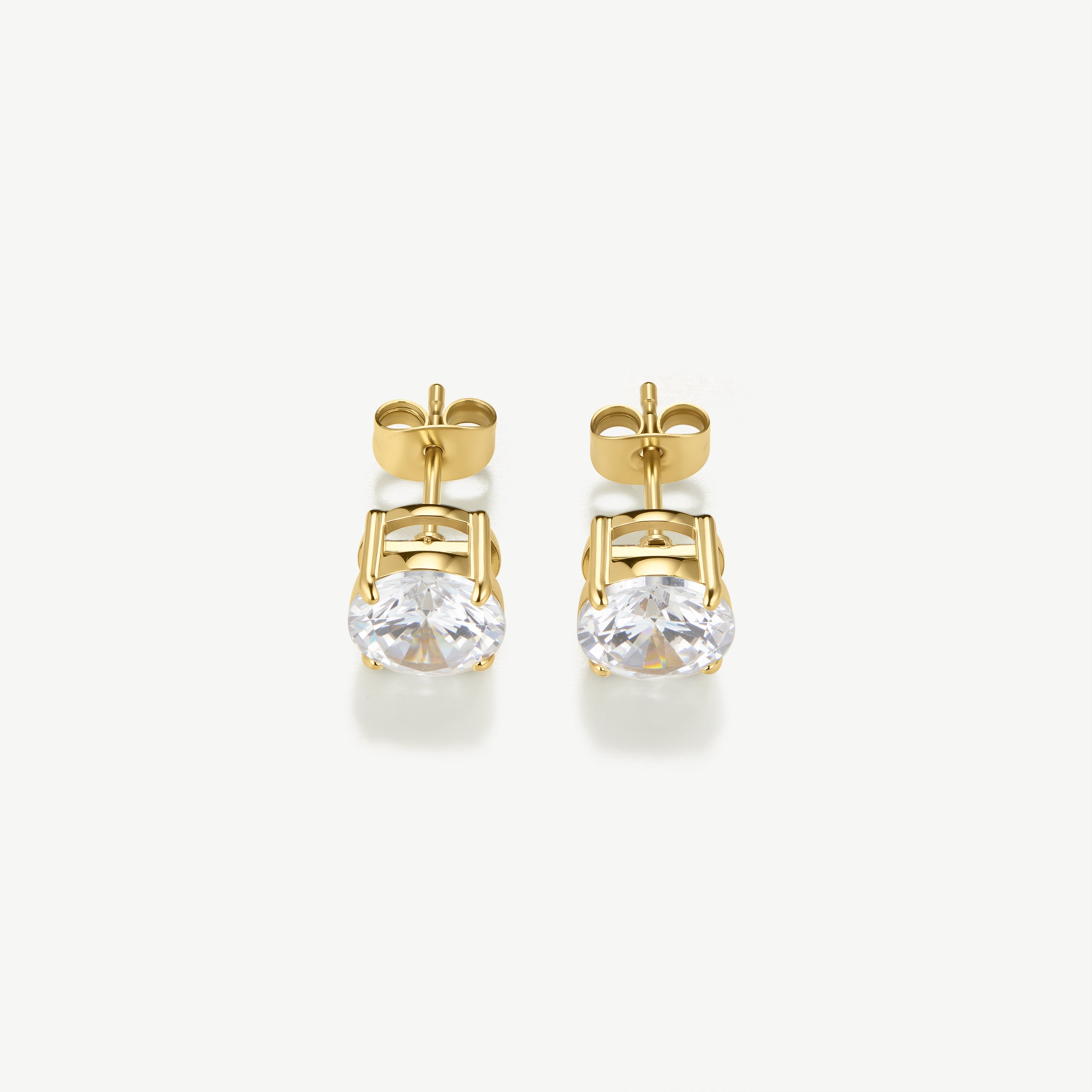 Gold earrings with clear gemstones on a white background